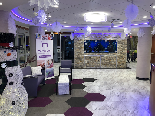 A modern lobby featuring a stylish seating area and an aquarium, illuminated with ambient lighting.