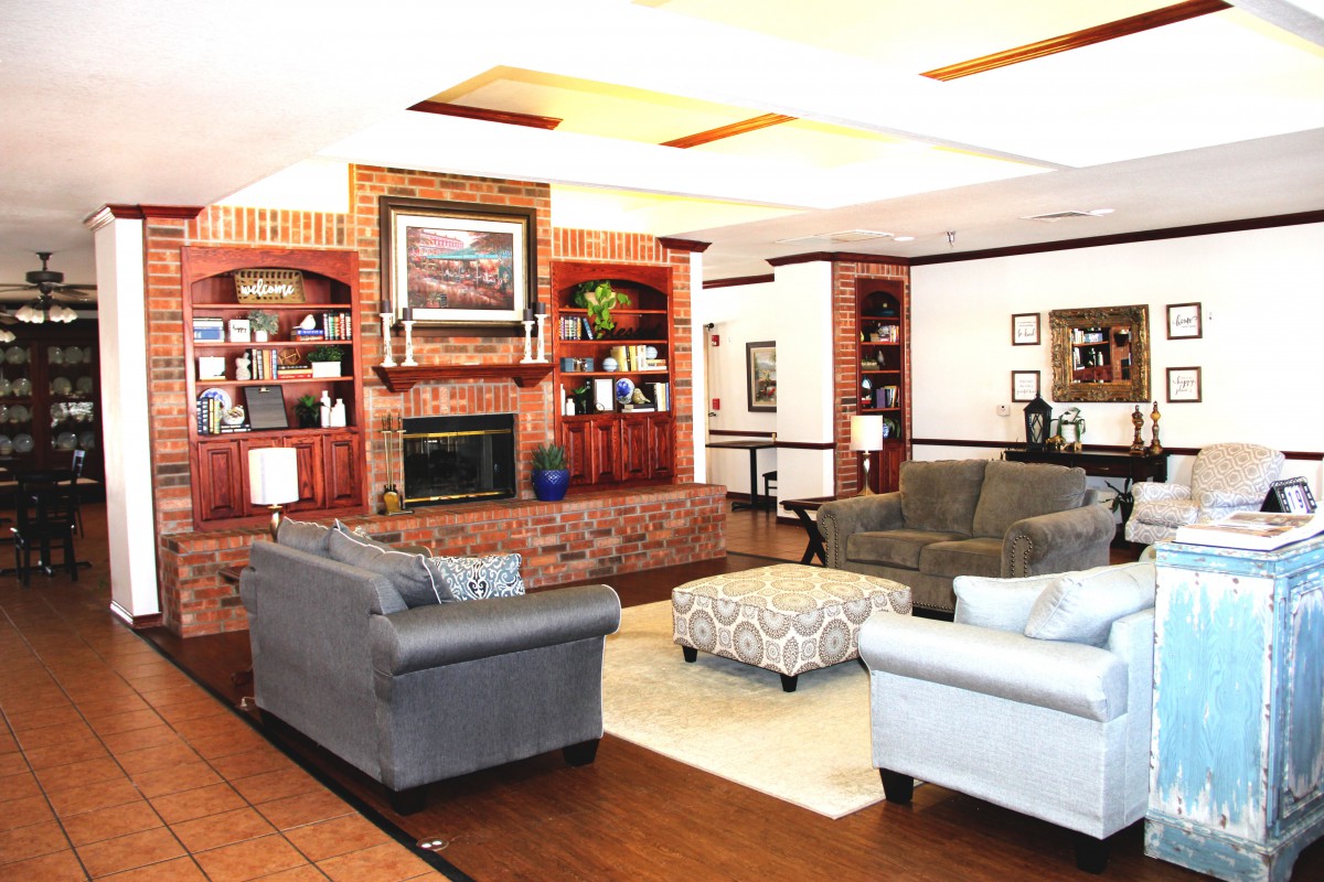 A cozy living room with a fireplace, sofas, and bookshelves.