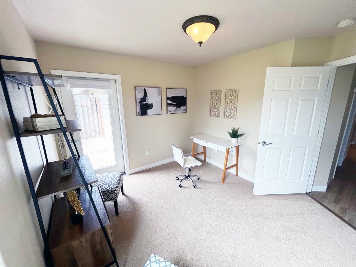 A modern home office with a desk, chair, and decorative wall art.
