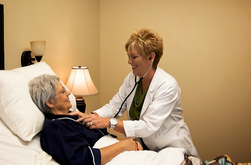 A healthcare professional conducting a check-up on an elderly patient in a clinical setting.