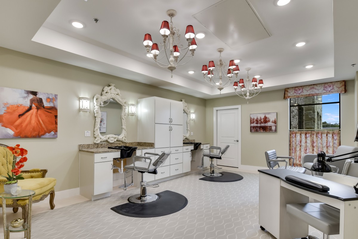 A modern and elegant salon interior with styling chairs and decorative lighting.