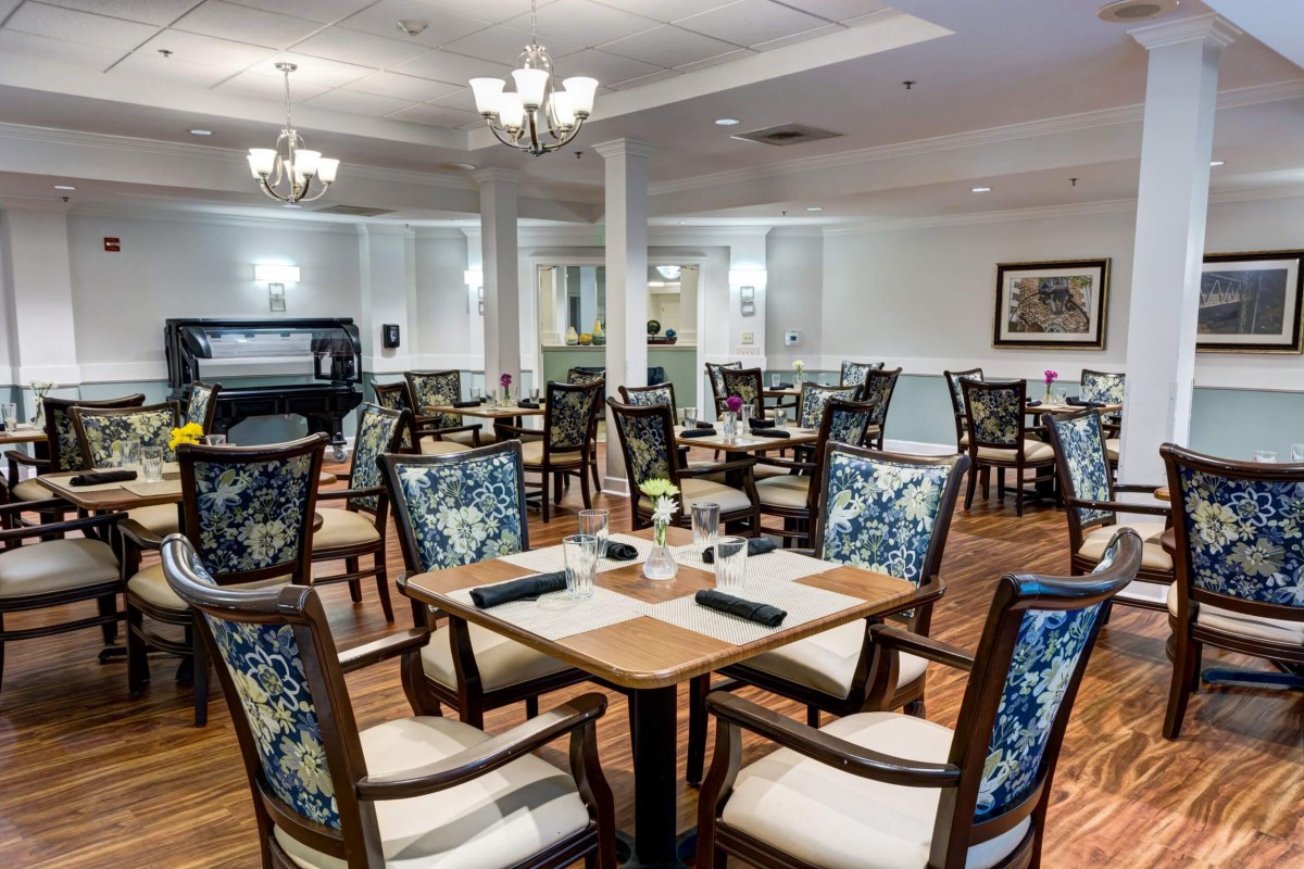 An elegant restaurant dining area featuring well-arranged tables and chairs with a classic decor.