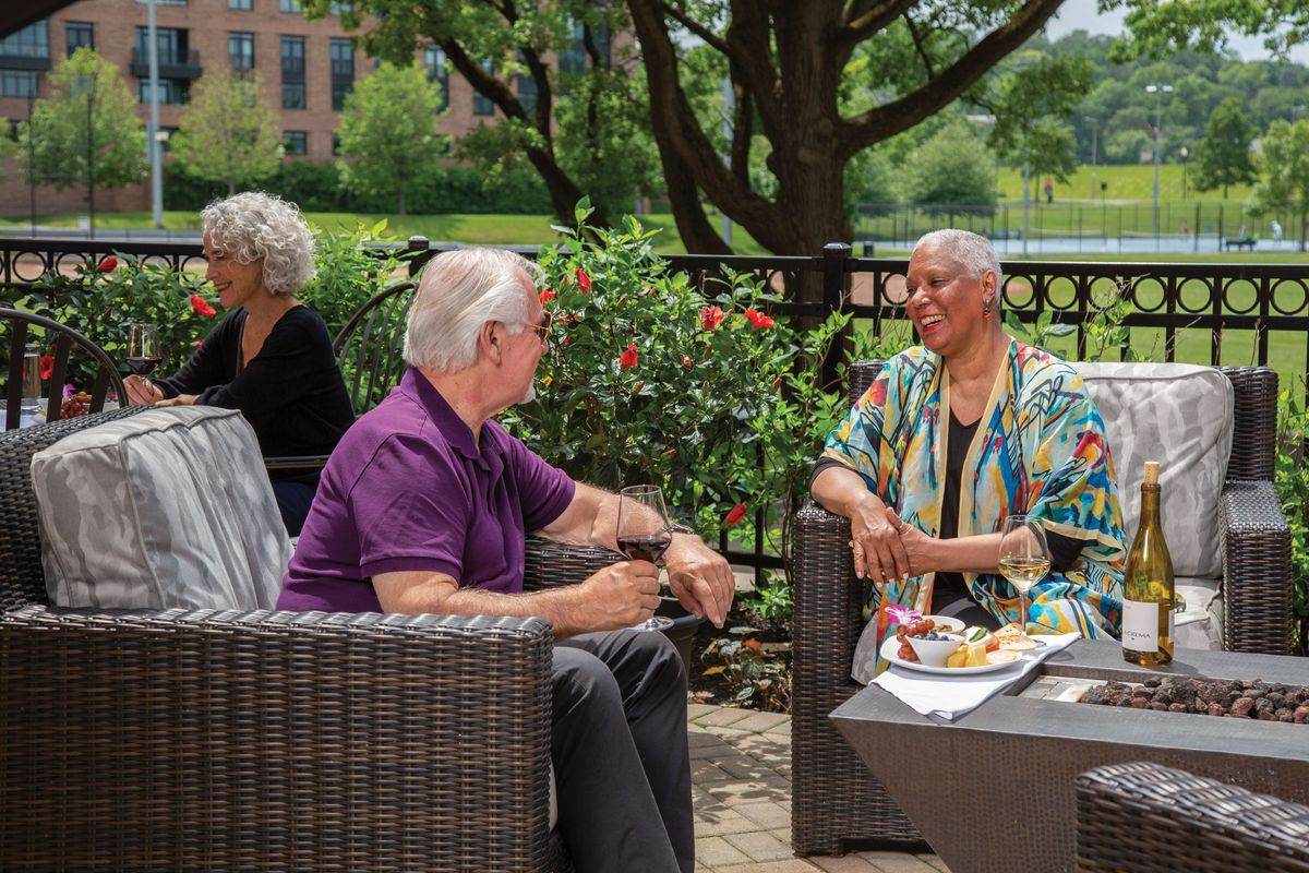 A group of seniors enjoying a conversation on an outdoor patio.