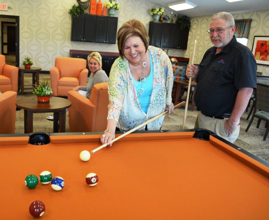 People enjoying a game of billiards in a recreation room.