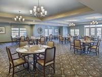 A spacious dining room with elegantly set tables and chandeliers.