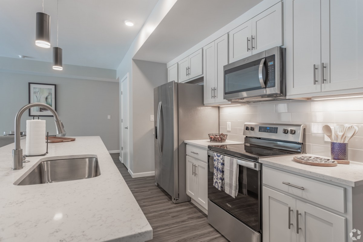 A modern kitchen with stainless steel appliances and white cabinetry.