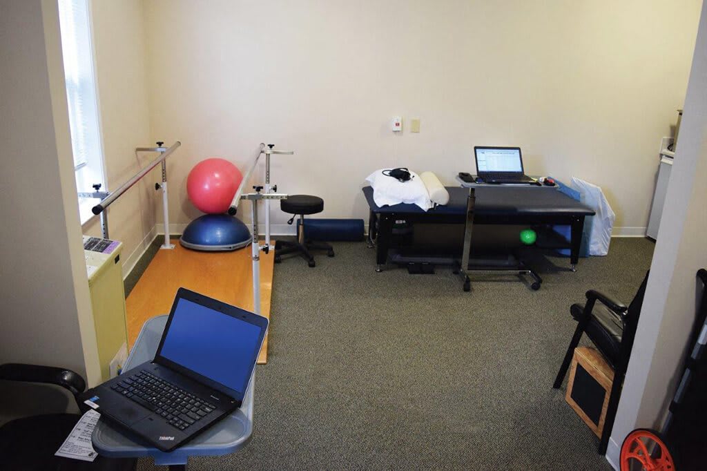 A physical therapy room equipped with exercise equipment and computers.
