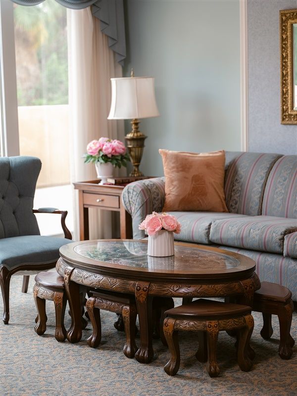 A cozy living room with elegant furniture and floral decor.