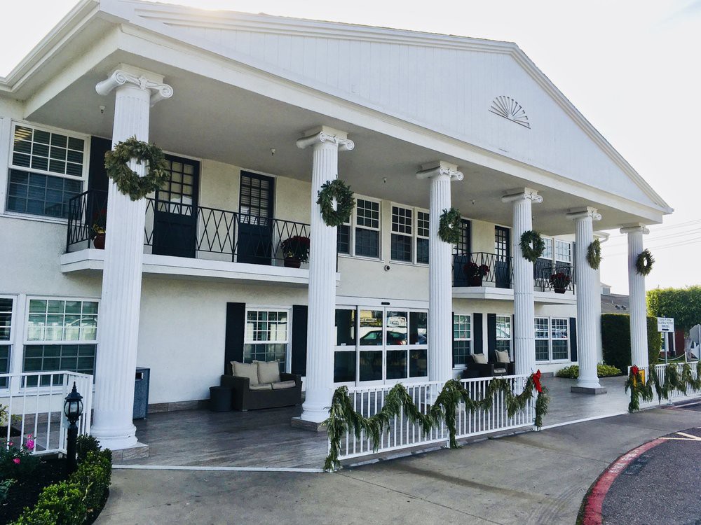 A colonial-style building adorned with holiday wreaths and decorations.