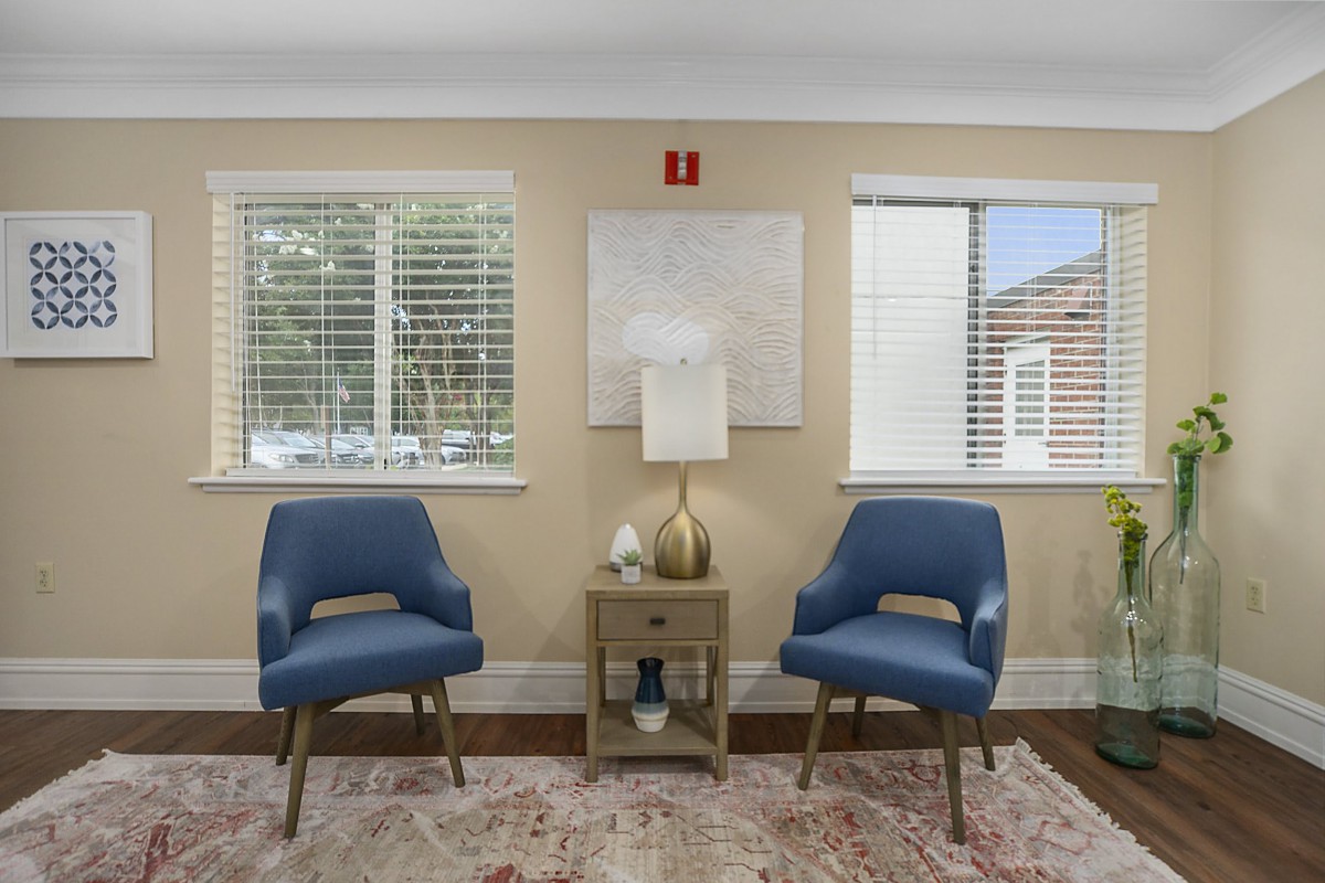 Cozy living room setup with two blue chairs, a central table, and decorative accents.