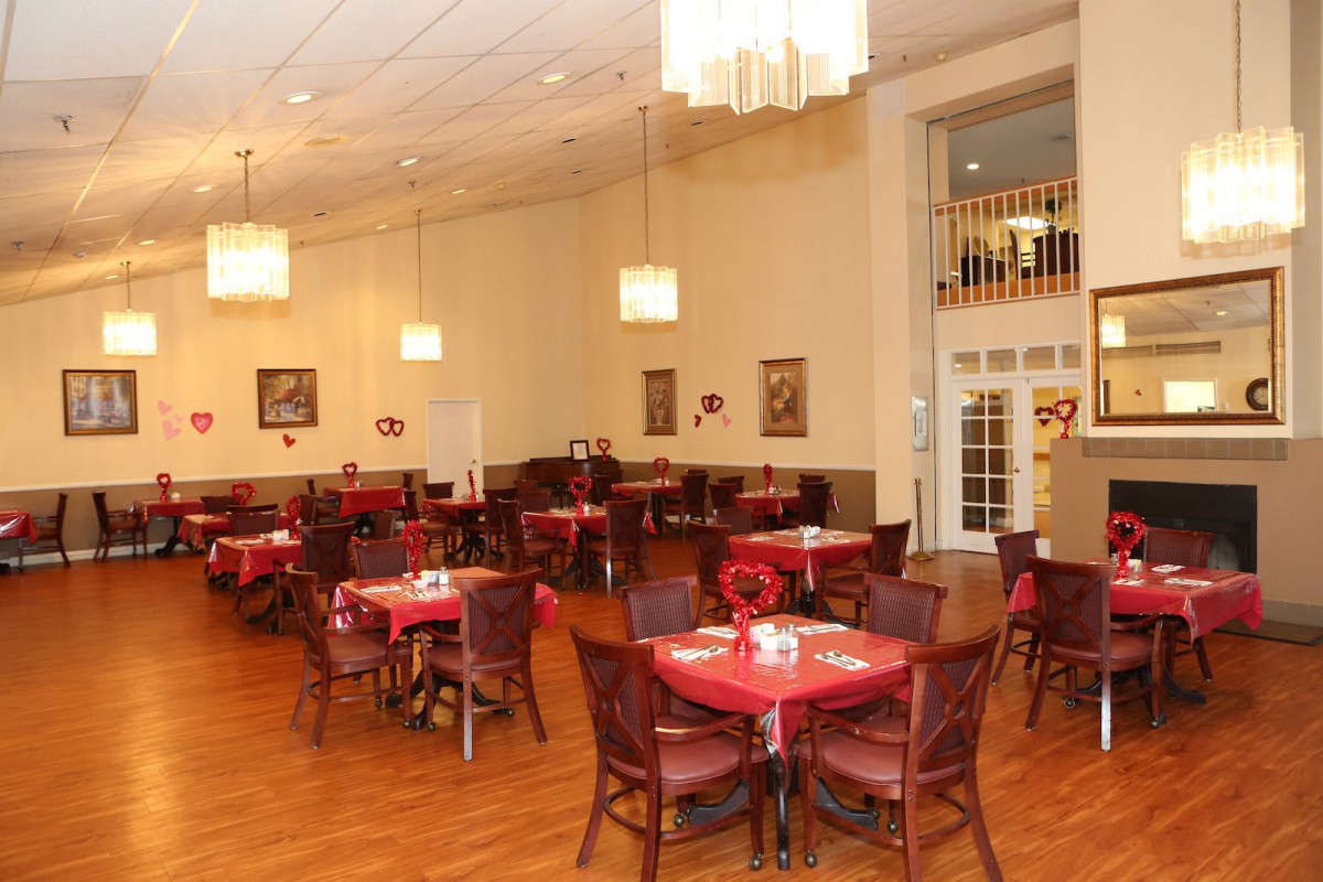 A cozy restaurant dining room with neatly arranged tables and warm lighting.