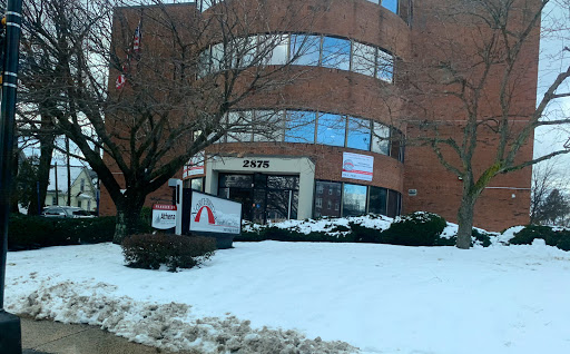 A brick office building partially covered in snow during winter.