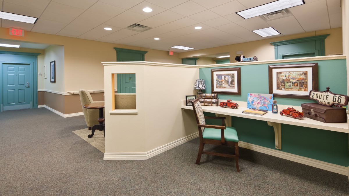 A modern office cubicle with desk and chair in a well-lit workspace.
