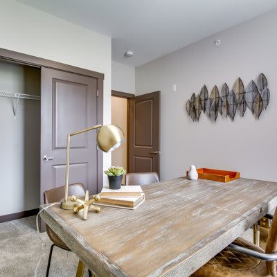 A modern office space featuring a wooden table, chairs, and decorative wall art.
