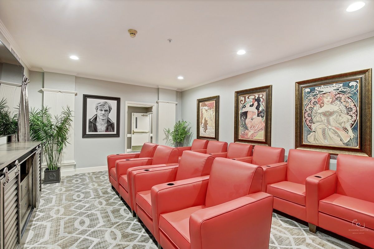 A stylish home theater with red seating and wall art.