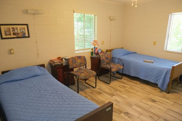 A cozy bedroom with two twin beds and blue bed covers.