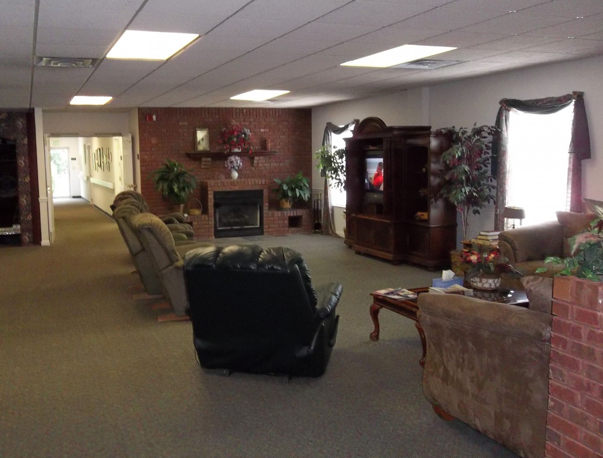 A cozy lounge area with armchairs, a sofa, and a fireplace.