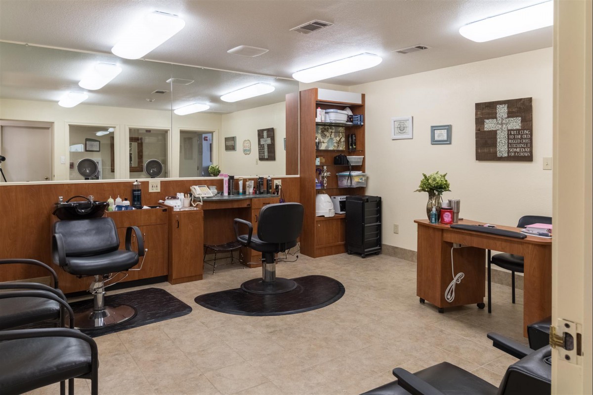 Interior of a salon featuring styling chairs, mirrors, and workstations.