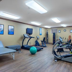 A well-equipped gym with treadmills, stationary bikes, and exercise equipment.