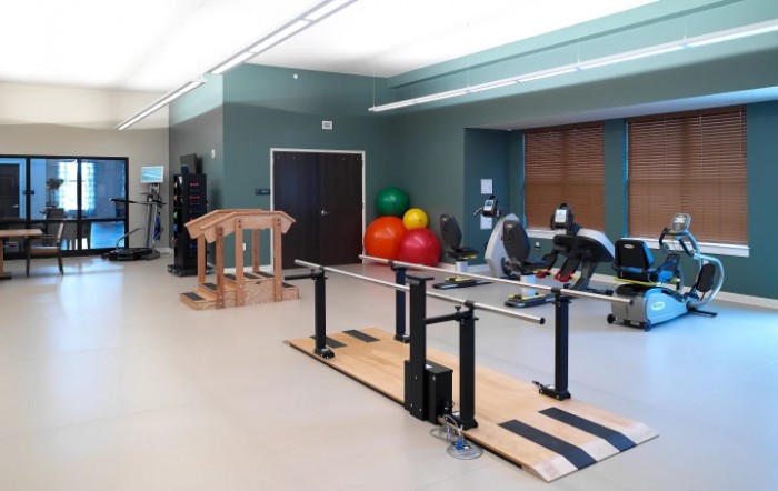 A well-equipped rehabilitation gym with exercise equipment and therapy tools.