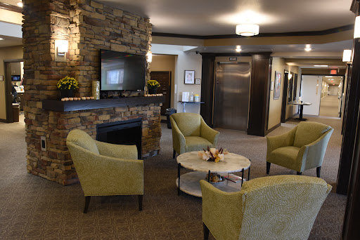 A cozy and inviting lobby area featuring comfortable seating, a stone fireplace, and modern decor.