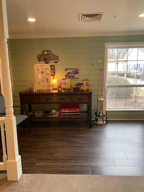 A cozy living room with a console table adorned with various decorations, next to a large window.
