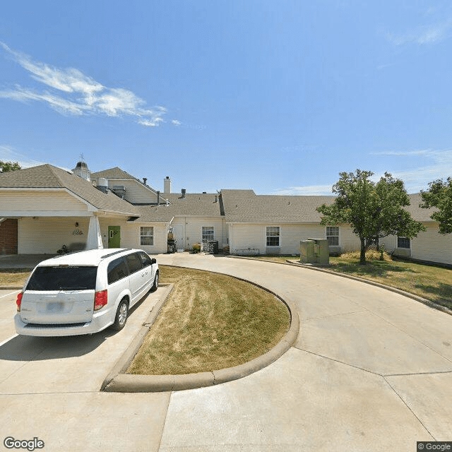 A suburban driveway with a parked car under a clear sky.