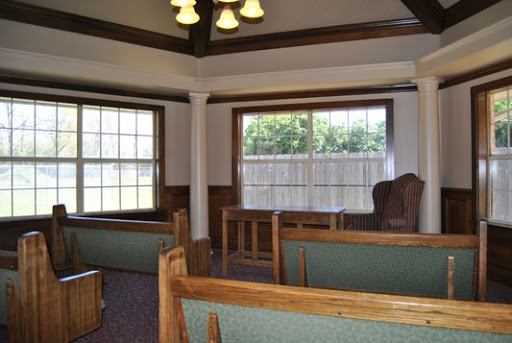 A cozy interior space featuring wooden furniture, ample seating, and natural light streaming through the windows.