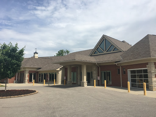 A modern architectural building with a welcoming entrance under a cloudy sky.