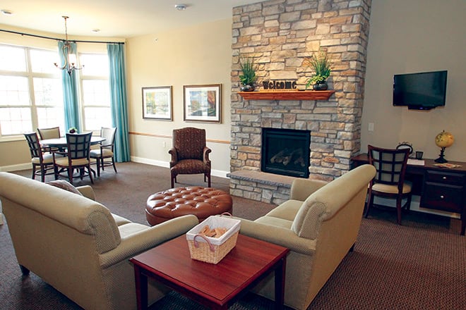 A cozy living room featuring a stone fireplace, comfortable seating, and tasteful decor.