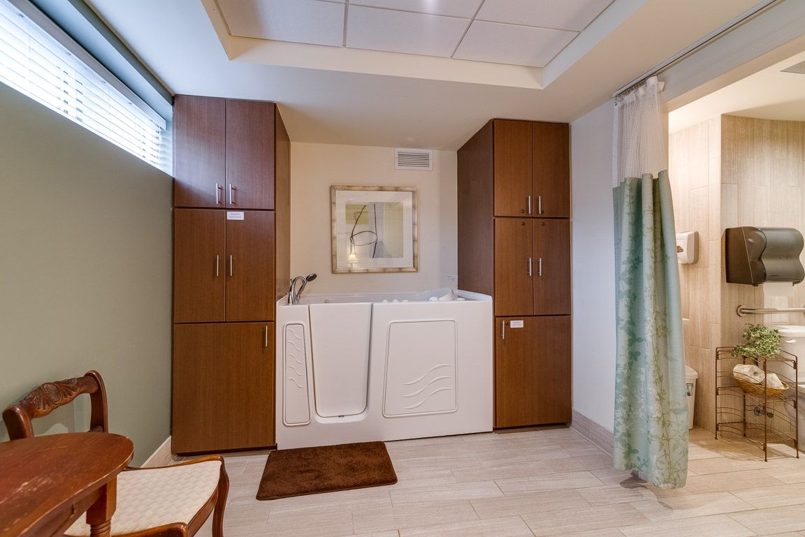 A bathroom with a walk-in tub and wooden cabinets, designed for accessibility and convenience.