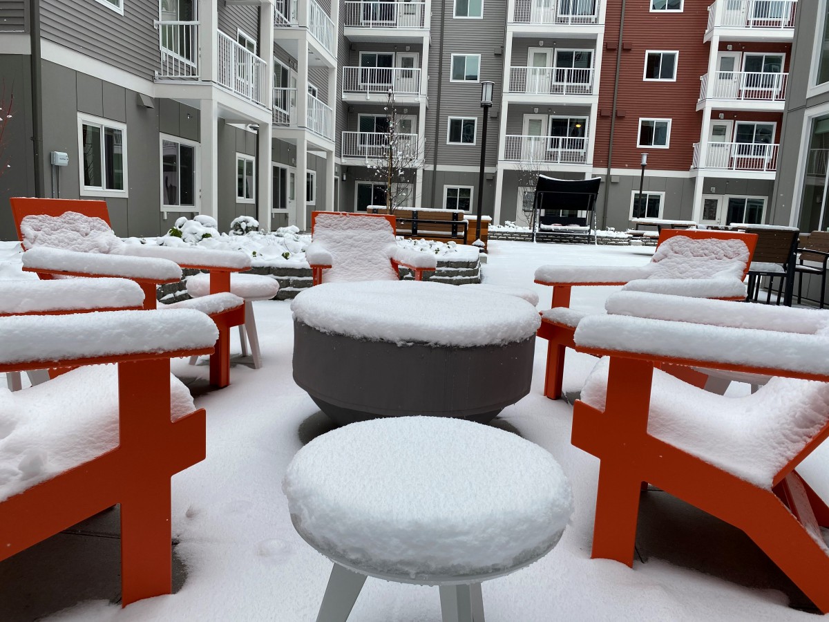 Snow-covered outdoor seating area in an apartment courtyard.