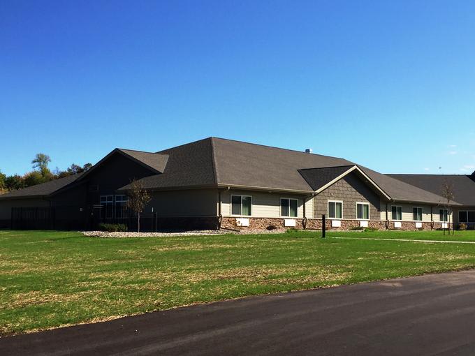 A suburban residential building with a neatly maintained lawn on a sunny day.