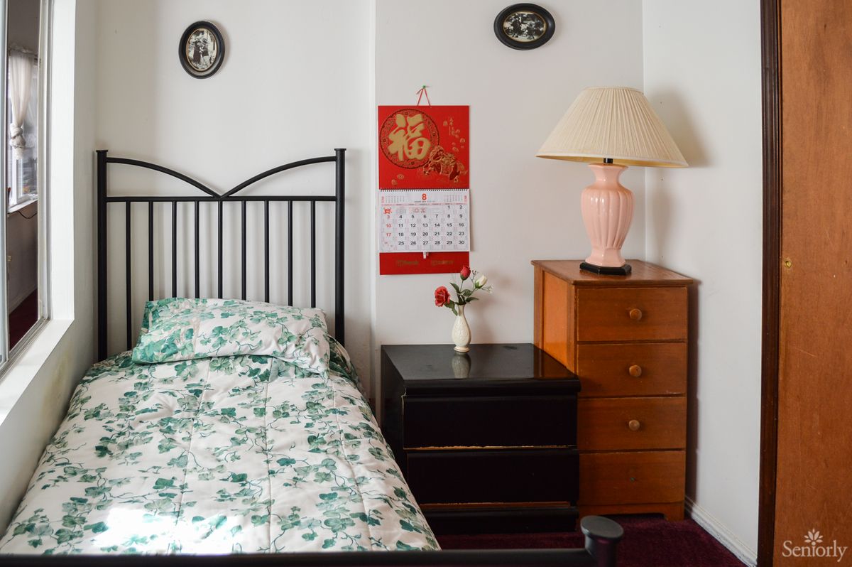 A cozy bedroom with a bed, nightstand, and decorative elements.