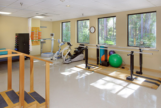 A bright and spacious fitness area equipped for rehabilitation and exercise with various workout tools.