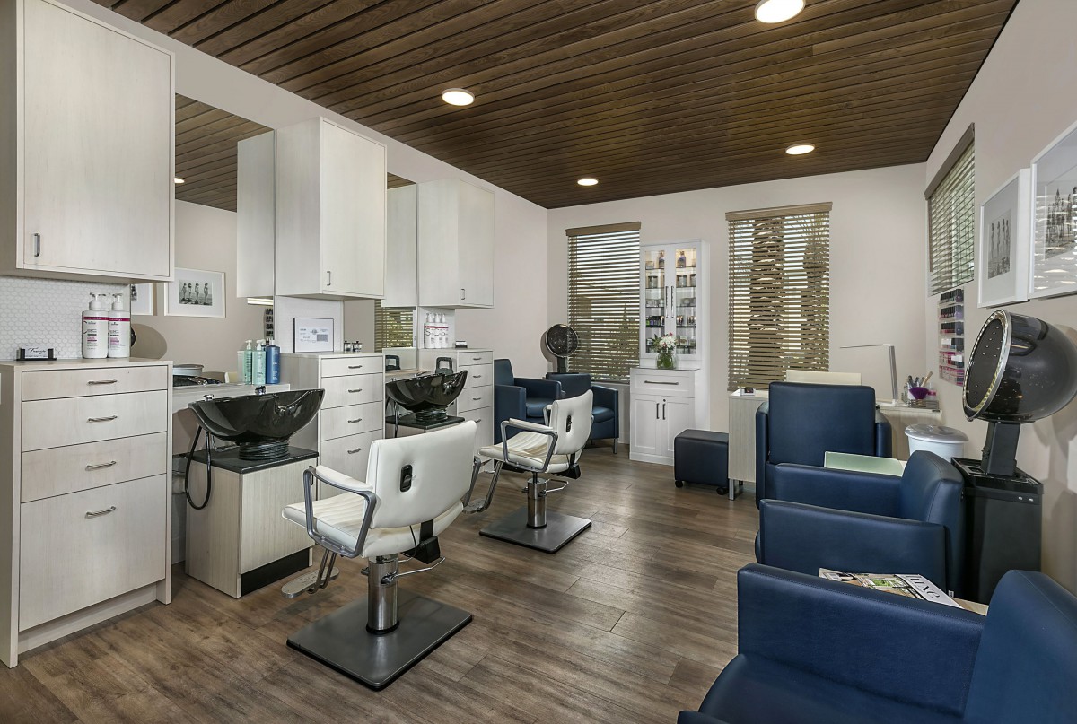 A modern, stylish hair salon interior with sleek chairs and clean decor.