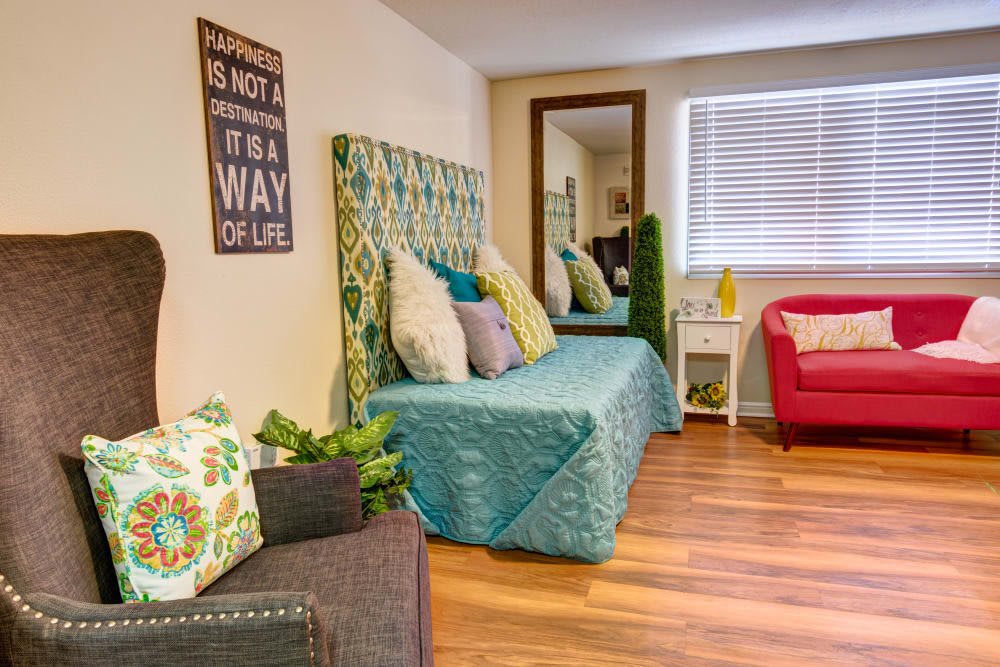 A cozy and colorful living room with a patterned bed, vibrant pillows, and elegant decor.