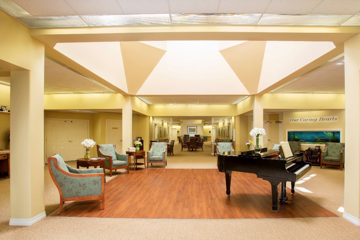 A spacious and elegantly designed lobby featuring a grand piano and comfortable seating.