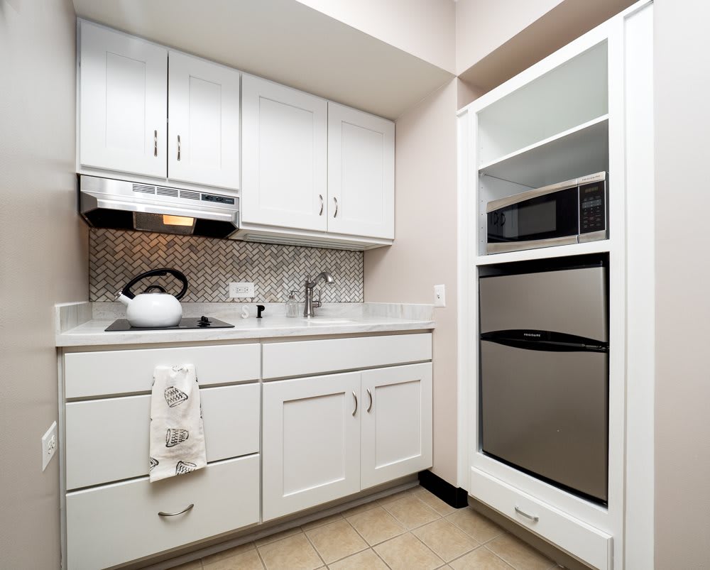 A modern kitchen with white cabinets and stainless steel appliances.