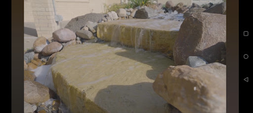 A serene waterfall cascading over natural stones, creating a peaceful outdoor ambiance.