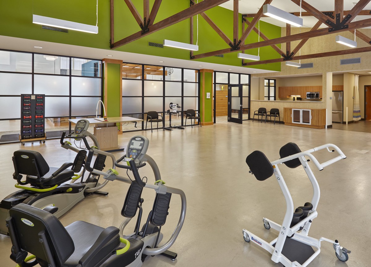 A spacious gym with modern exercise equipment and a bright interior.