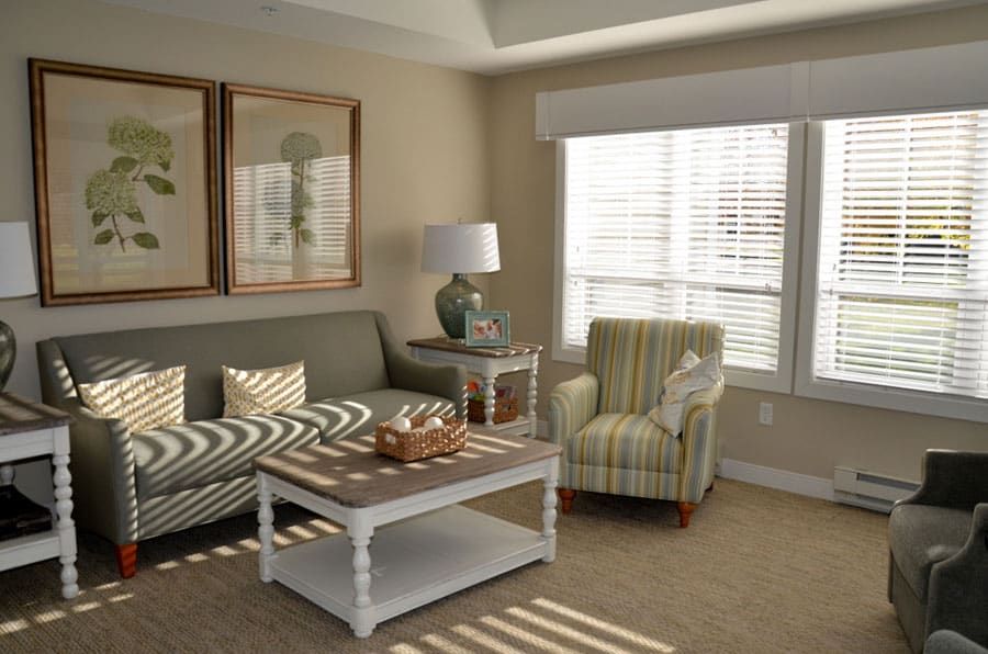 A cozy living room with a sofa, striped armchair, and decorated coffee table.