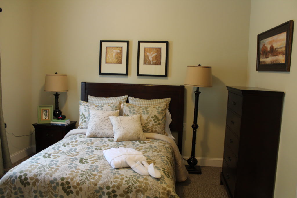 Cozy bedroom with decorative pillows and matching lamps.