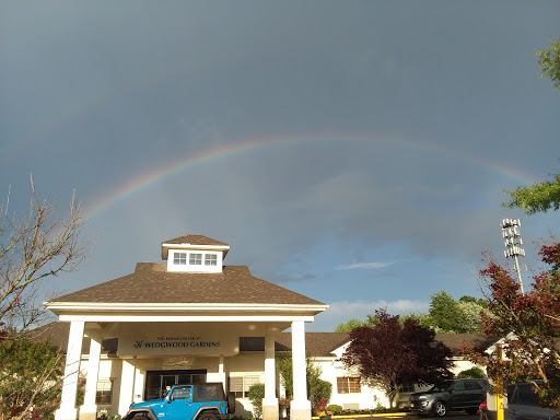 A beautiful rainbow arches over a building, contrasting against the dark sky.
