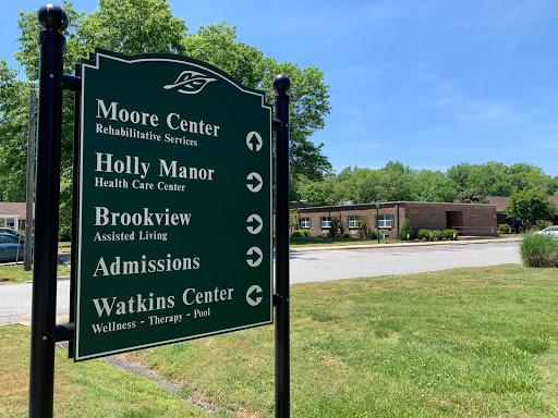 Signage indicating directions to various facilities, including Moore Center and admissions.
