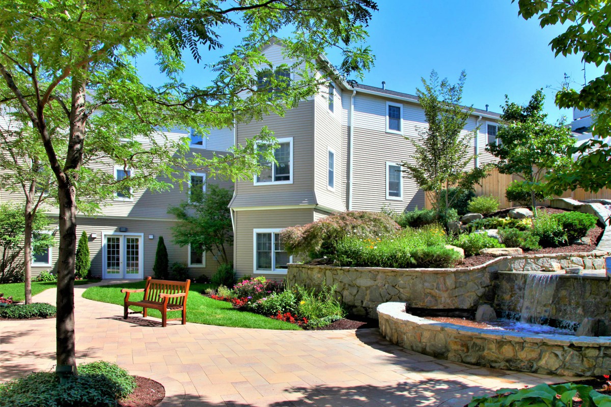 A modern house with a beautifully landscaped garden and patio area.