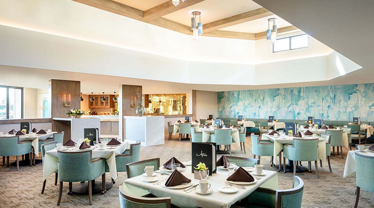 A well-lit and modern restaurant dining area with neatly arranged tables and chairs.