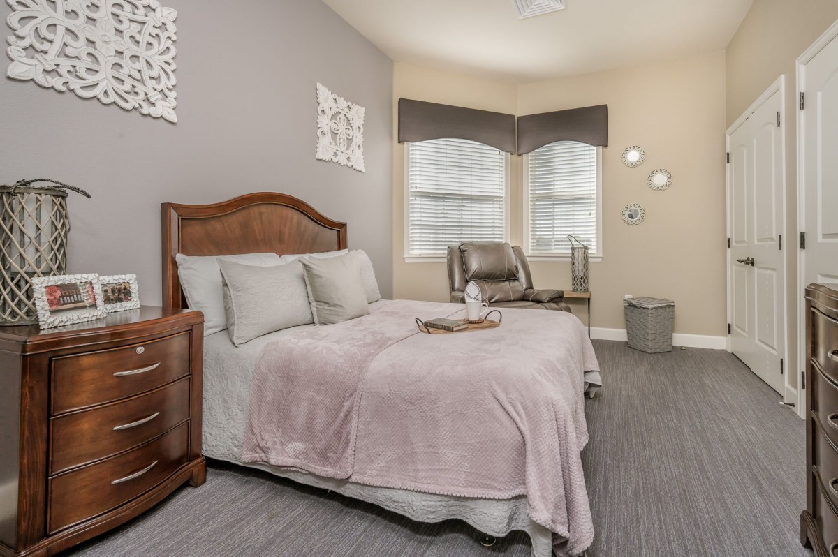 A cozy and well-decorated bedroom featuring a comfortable bed, nightstands, and stylish decor with natural light streaming through the windows.