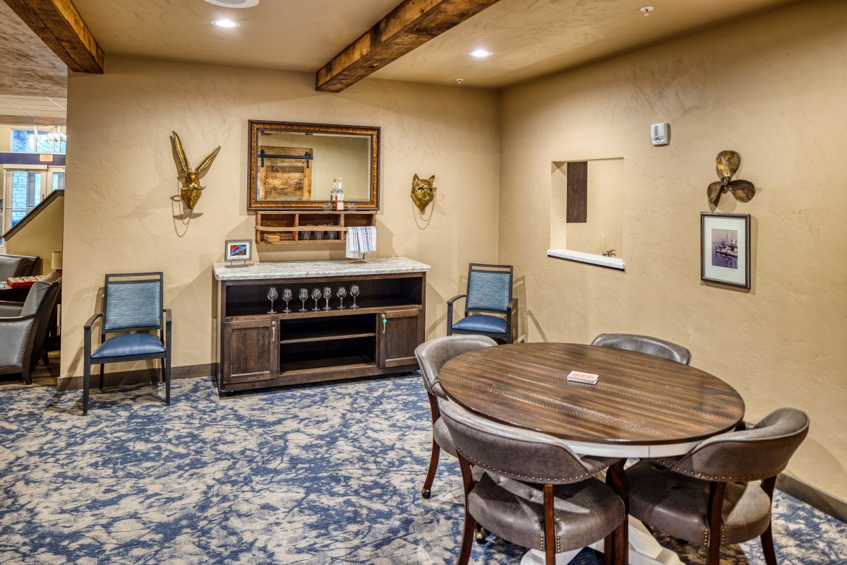 A cozy dining room with a round table, upholstered chairs, and elegant decor.
