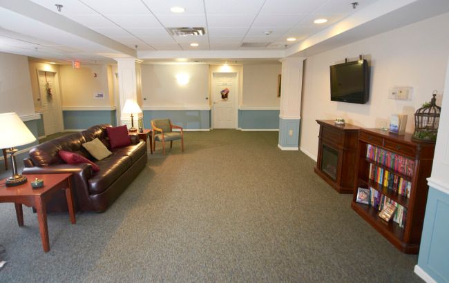 A cozy living room with a sofa, television, and carpeted floor.